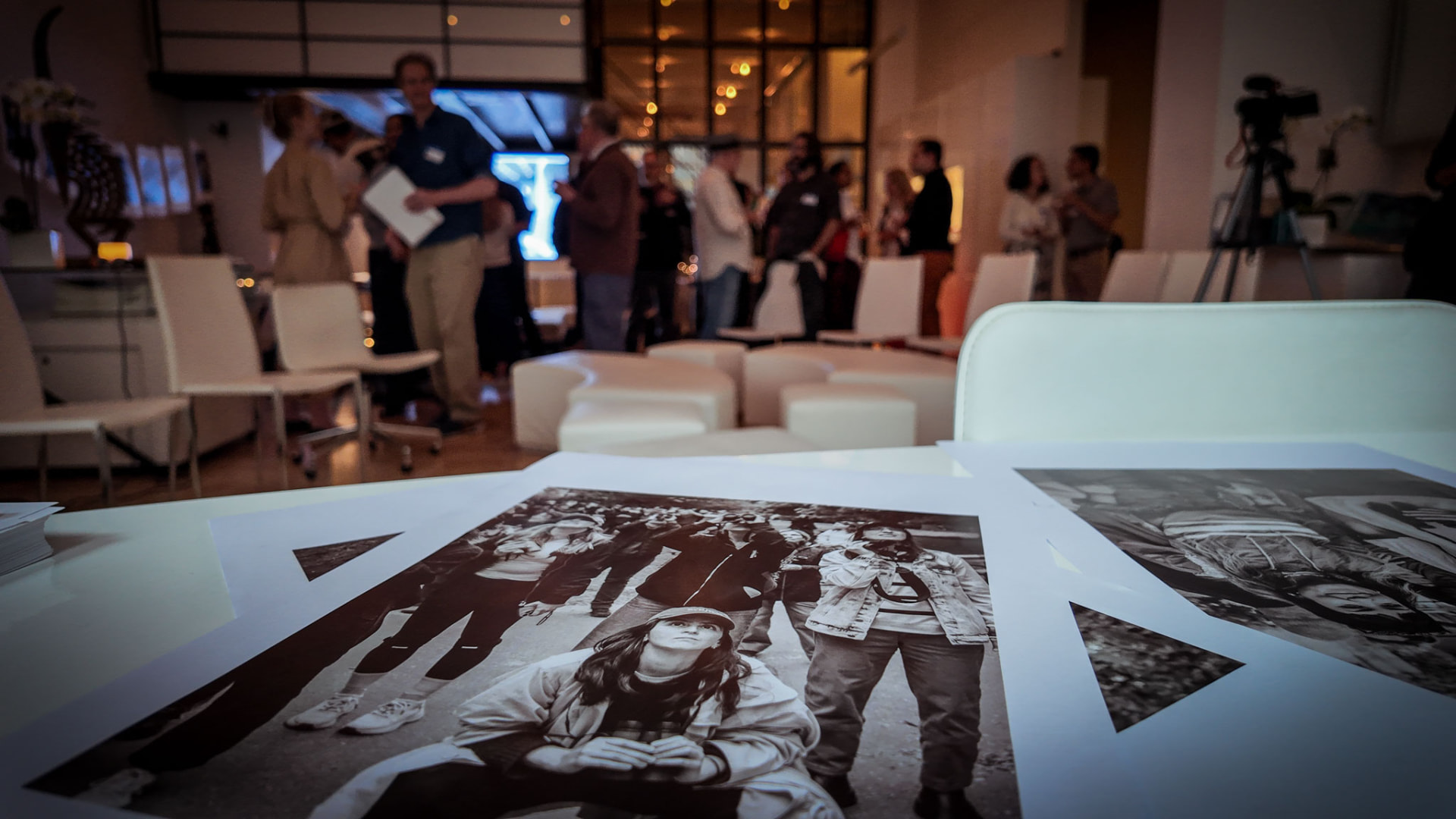 Black and white prints on a table with guests mingling behind